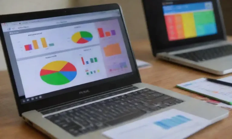 Laptop displaying a colorful analytics dashboard alongside marketing materials and a calculator.