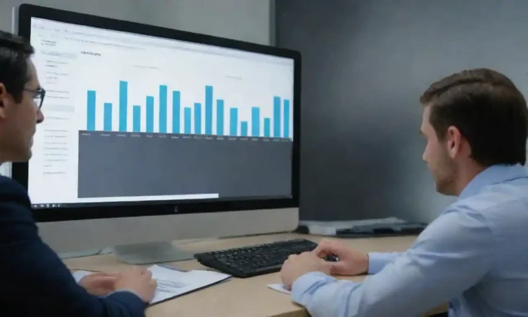 Gráfico de KPIs en una pantalla de computadora junto a un equipo discutiendo estrategia de CRM.