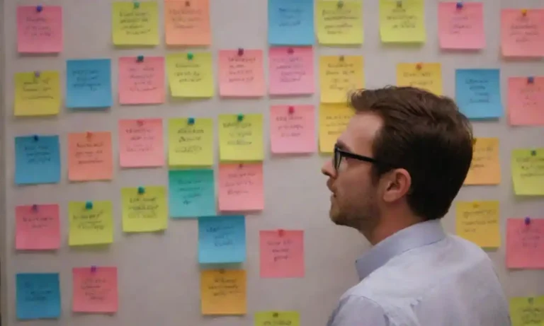 A person brainstorming catchy titles on a whiteboard surrounded by colorful sticky notes.