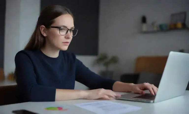 Marketer analyzing email metrics on a laptop with trendy design elements nearby.